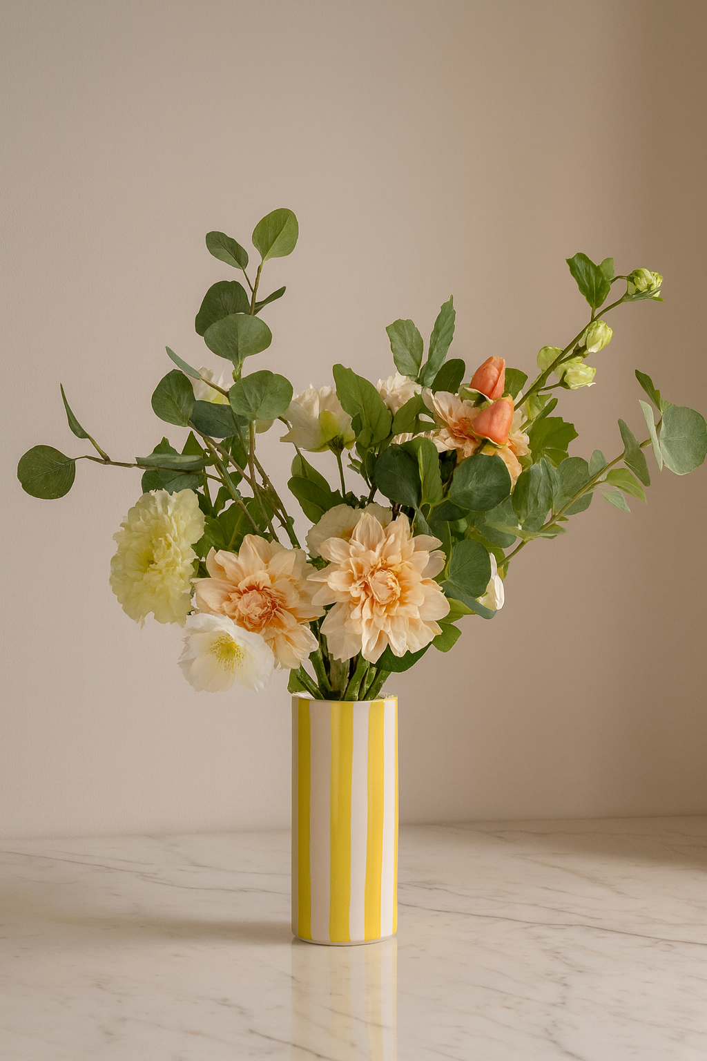 Composition dahlia pêche et hortensia vert dans vase rayé jaune